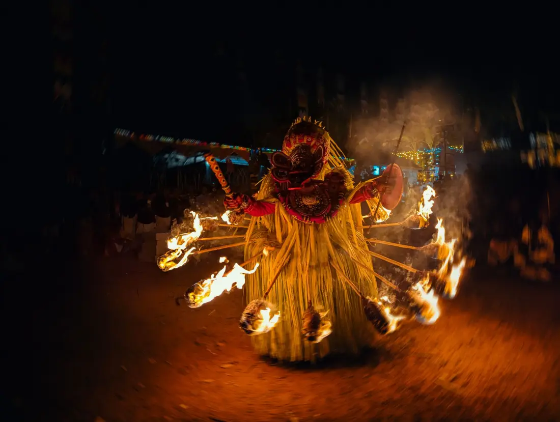 A fiery Theyyam ritual performer at night